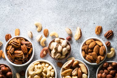 Fındık çeşitleri kaselerde. Ceviz, fındık, ceviz, badem, Brezilya fındığı ve şam fıstığı. Kopyalama alanı olan üst görünüm.