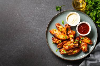 BBC soslu tavuk kanadı ızgara et. Restoran yemeği. Siyah taş masadaki üst görünüm.