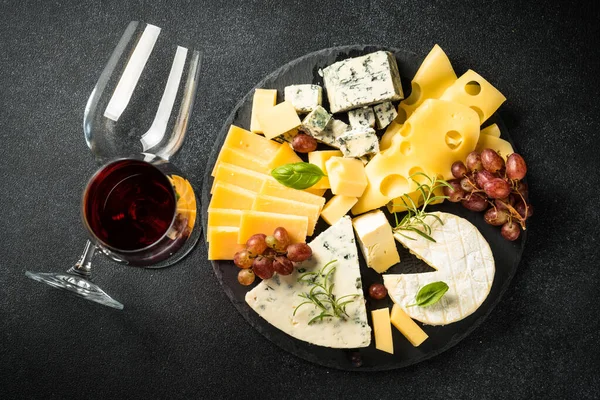 奶酪盘 红葡萄酒 黑色底色 板坯板上的奶酪 顶部视图 — 图库照片