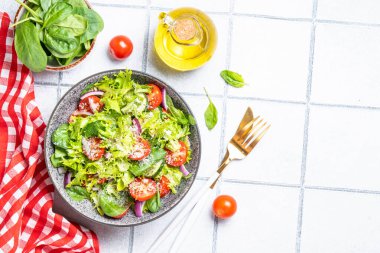 Taze yapraklı yeşil sebze salatası. Beyaz fayans arkaplanındaki üst görünüm.