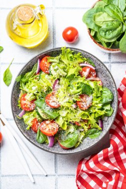 Taze yapraklı yeşil sebze salatası. Sağlıklı yemekler, diyet menüsü. Beyaz fayans arkaplanındaki üst görünüm.