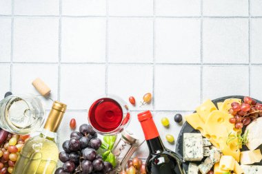 Şarap seti, peynir çeşitleri ve beyaz fayanslı taze üzüm. Metin için boşluk ile düz uzandı.