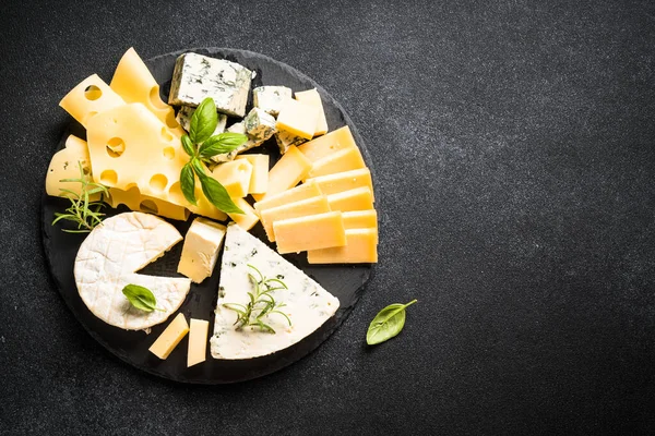奶酪盘与工艺奶酪分类在板岩板上的黑色背景 带有复制空间的顶部视图 — 图库照片