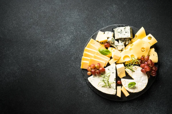 奶酪盘 带有手工奶酪和葡萄的黑色背景 带有复制空间的顶部视图 — 图库照片
