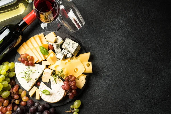 チーズプラッターと赤ワイン スレートボードにグレープをセットしたクラフトチーズ ブラックバックでのトップビュー — ストック写真