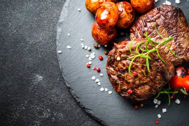 Barbekü yemeği. Sebzeli et biftekleri ve siyah arka planda otlar. Kopyalama alanı olan en üst görüntü.