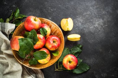 Siyah taş masadaki sepetin içinde taze olgun elmalar. Kopyalama alanı olan üst görünüm.