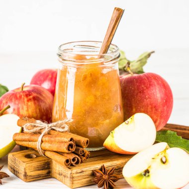 Baharatlı elma reçeli ve beyaz arkaplanda taze elma.