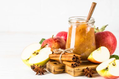 Baharatlı elma reçeli ve beyaz arkaplanda taze elma.