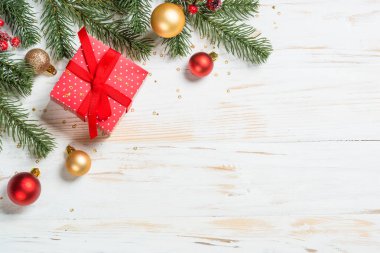 Noel arkaplanı bembeyaz. Kırmızı kurdeleli ve Noel süslemeli Noel hediyesi kutusu. Kopyalama alanı olan düz resim.