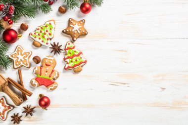 Noel zencefilli ekmeği tabakta baharat ve süslemeler beyaz ahşap masada. Noel pastası. Kopyalama alanı olan üst görünüm.