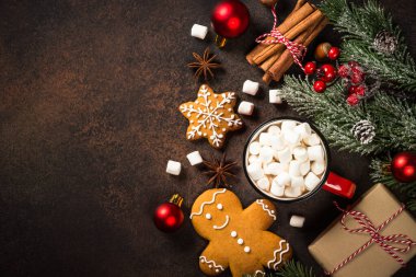 Sıcak çikolata ve zencefilli kurabiye. Koyu taş masada noel süslemeleri. Kopyalama alanı olan üst görünüm.