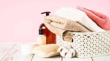 Banyo arkaplanı. Banyo havluları, şampuanlı şişeler ve tuvalet masasında krema kavanozları..