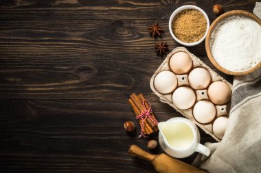 Pişirme malzemeleri - un, şeker, süt ve baharatlar. Kırsal ahşap masadaki en üst manzara.