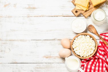 Süt ürünleri beyaz tahta masada. Krema, süt, yoğurt, peynir ve yumurta. Organik çiftçi yemeği. Kopyalama alanı olan üst görünüm.