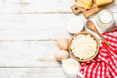 Süt ürünleri beyaz tahta masada. Krema, süt, yoğurt, peynir ve yumurta. Organik yiyecekler. Kopyalama alanı olan üst görünüm.