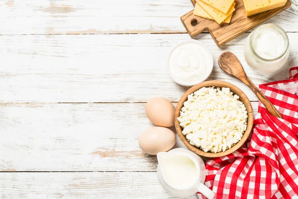 Süt ürünleri beyaz tahta masada. Krema, süt, yoğurt, peynir ve yumurta. Organik yiyecekler. Kopyalama alanı olan üst görünüm.