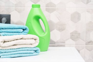 Banyo havlusu ve deterjan yığını. Çamaşırhanede ya da banyoda temiz havlu var..