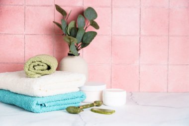 Temiz havlular ve kozmetik ürünler banyoda..