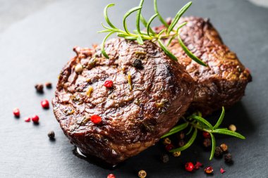 Et biftekleri. Taş tahtada baharatlı ve otlu sığır eti madalyonları. Kapat..