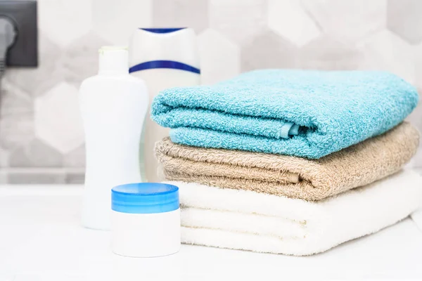Clean towels and cosmetic products at the washing machine in the bathroom.