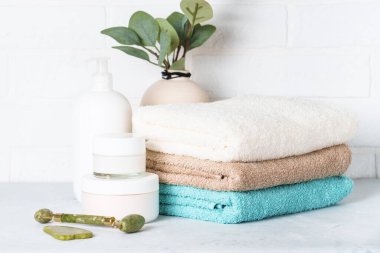 Kozmetik ürünler ve temiz havlular banyoda. Spa ve güzellik ürünleri.
