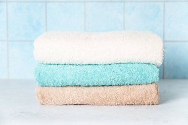 Çamaşırhanede temiz havlular ya da mavi duvara dayalı bir banyo..