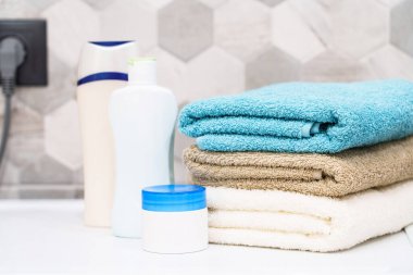 Banyodaki çamaşır makinesinde temiz havlular ve kozmetik ürünler..