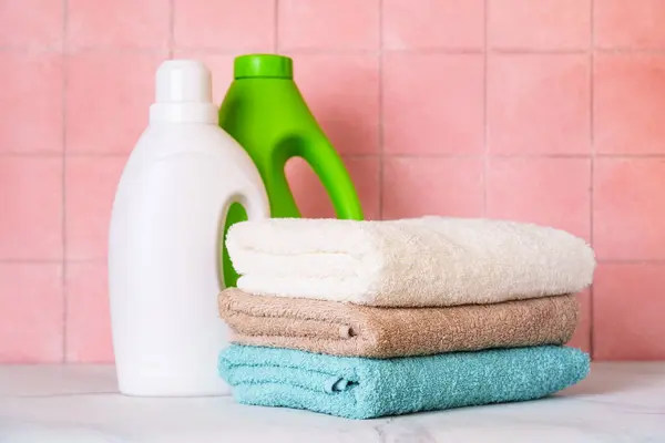 洗衣房或浴室里的干净毛巾和洗涤剂要靠在瓷墙上 — 图库照片