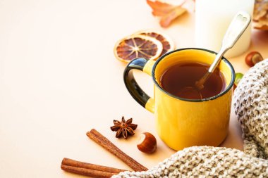 Sonbahar arkaplanı. Sıcak çay, baharatlar, portakal yaprakları ve ev dekoru..