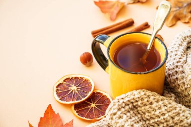 Bir fincan çay, baharat, kuru yapraklar ve sıcak örülmüş süveter. Samimi sonbahar kompozisyonu.