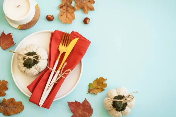 Autumn food background. White plate, cutlery and autumn decorations. Flat lay with copy space.