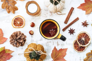 Arka planda kal. Beyazın üstünde sıcak bir sonbahar. Baharatlı çay, sonbahar yaprakları, baharatlar ve dekor. Kopyalama alanı olan düz.