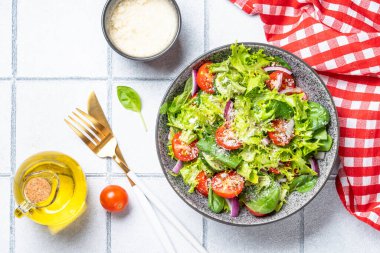 Taze yapraklı yeşil sebze salatası. Beyaz fayans arkaplanındaki üst görünüm.