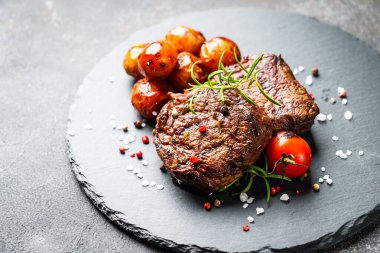Siyah tahtada sebzeli et biftekleri ve otlar. Barbekü yemeği, restoran yemeği..