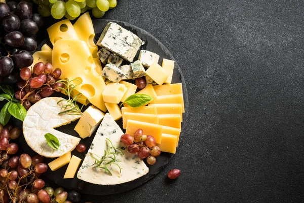 奶酪盘与工艺奶酪分类和葡萄在板板上 平面上有文字的空间 — 图库照片