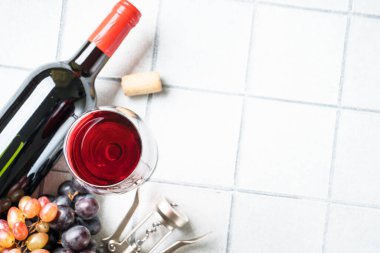 Beyaz arka planda kırmızı şarap. Bir bardak şarap, şişe, tirbuşon ve krep. Kopyalama alanı olan üst görünüm.