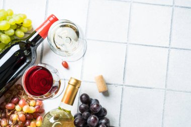 Beyaz fayanslı taze üzümlü şarap seti. İki kadehte beyaz ve kırmızı şarap. Metin için boşluk ile düz uzandı.