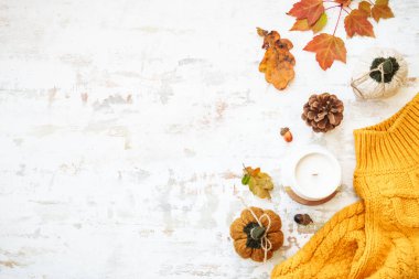 Sıcak kazak, sonbahar yaprakları, mum ve dekor. Kopyalama alanı olan düz resim.