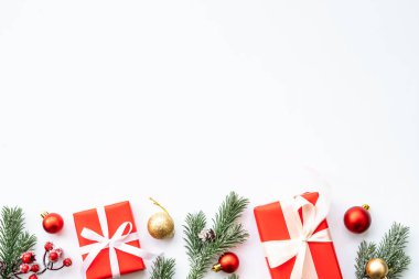 Noel hediyesi kutusu ve beyaz arka planda kırmızı süslemeler. Kopyalama alanı olan düz.