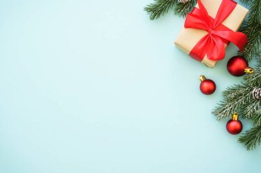 Noel arkaplanı. Şimdiki kutu ve kırmızı süslemeler mavi arka planda. Kopyalama alanı olan düz resim.