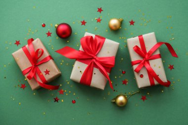 Noel hediyesi ve arka planda kırmızı süslemeler. Kopyalama alanı olan düz resim.