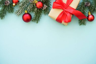 Noel arkaplanı. Şimdiki kutu ve kırmızı süslemeler mavi arka planda. Kopyalama alanı olan düz resim.