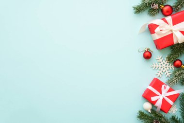 Mavi arka planda köknar ağacı olan Noel hediyeleri ve süslemeler. Kopyalama alanı olan düz resim.