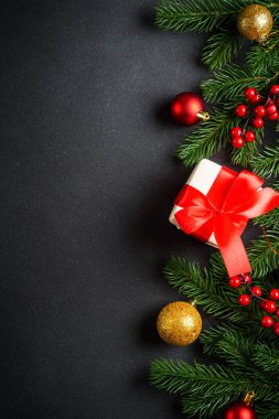 Noel arkaplanı, Noel ağacı, hediye kutusu ve siyahta tatil süslemeleri. Kopyalama alanı ile dikey resim yatıyordu.