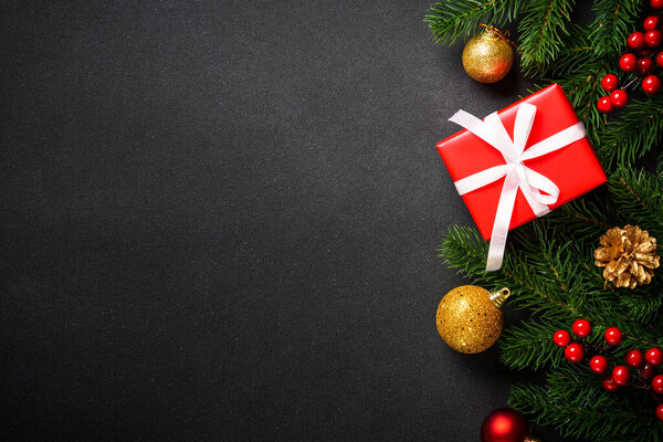 Черно-белый плоский фон. Рождественская елка с коробкой подарков и праздничные украшения в черном.