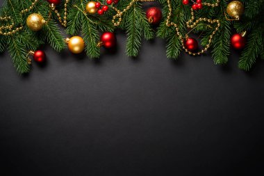 Siyah Noel arkaplanı dümdüz uzanıyordu. Siyah arka planda tatil süslemeleri olan Noel ağacı.