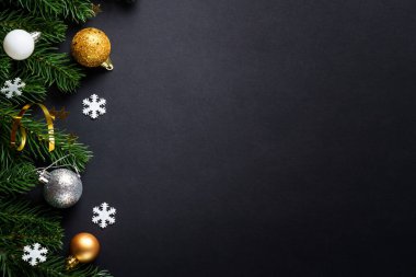 Noel tebrik kartı. Beyaz ve altın renkli tatil süslemeleri olan bir Noel arkaplanı. Simsiyah kopyalama alanı olan düz uzandı.