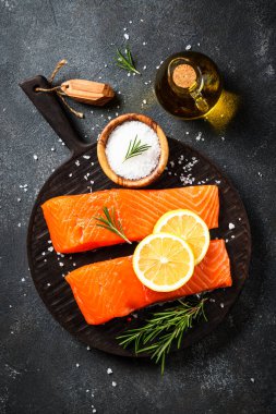 Siyah masada çiğ balık. Limon ve baharatlı somon filetosu. Düz yatıyordu.