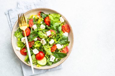 Ispanaklı yeşil salata, roka ve zeytinyağlı domates. Beyaz üzerine üst görünüm.